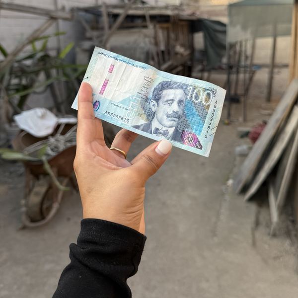 Billete de 100 soles en la mano